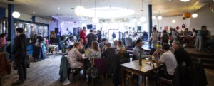 Interior of the cafe space with people sitting around tables